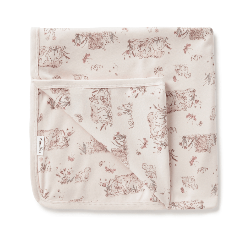 An adorable Aster & Oak organic cotton baby swaddle wrap with a hand-illustrated print of animals, in pink and brown.