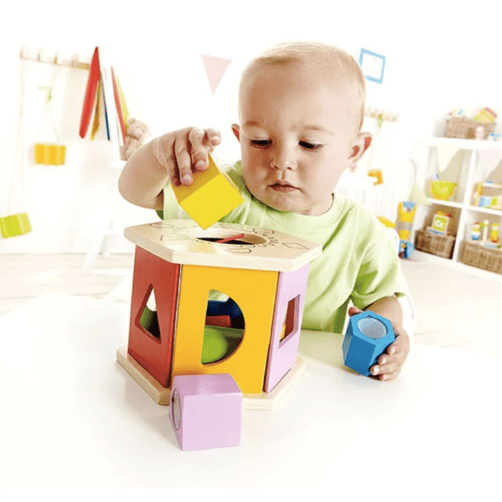 Little-Baby-Putting-Yellow-Shape-Into-Hape-Shake-And-Match-Shape-Sorter-Naked-Baby-Eco-Boutique
