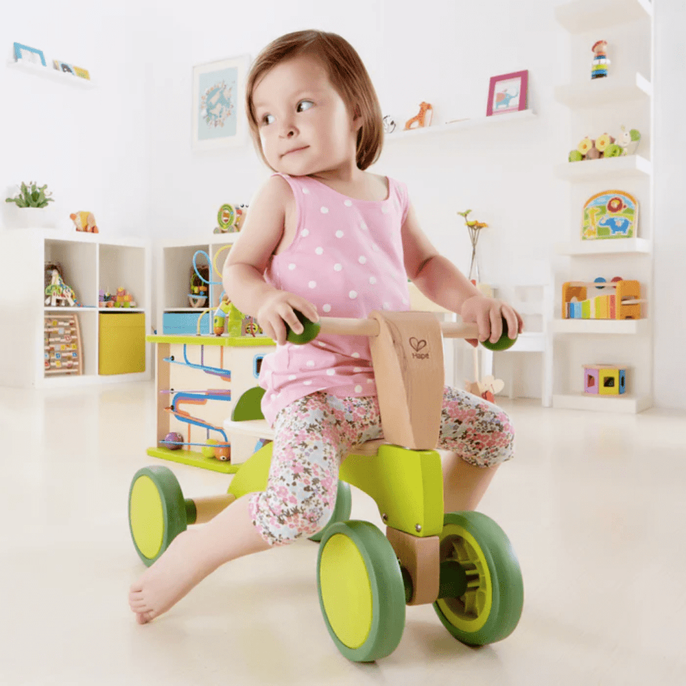 Little-Girl-Riding-On-Hape-Scoot-Around-Naked-Baby-Eco-Boutique