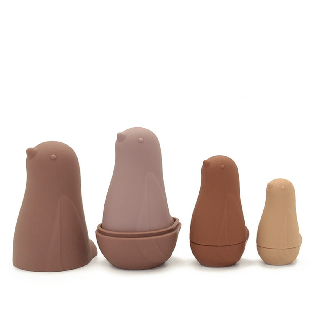 A group of durable brown Classical Child Silicone Stacking Dolls shaped like stacking dolls, with a bird in the middle.