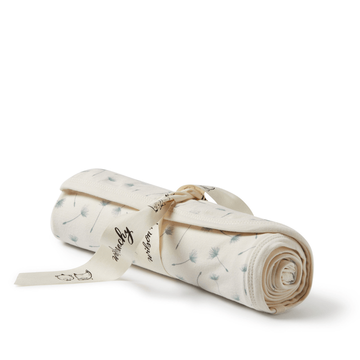 A luxury Wilson & Frenchy organic baby swaddle blanket with a ribbon on it.