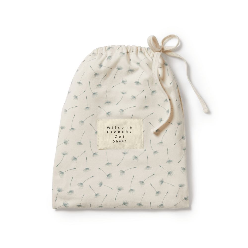An Wilson & Frenchy Organic Cotton Cot Sheet - LUCKY LASTS - FLOAT AWAY ONLY with a dandelion print, perfect as a baby shower present.