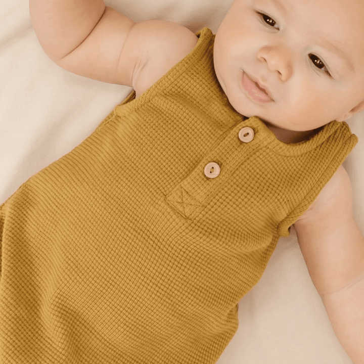 Close-up-of-Baby-Wearing-Quincy-Mae-Organic-Waffle-Sleeveless-Bubble-Romper-Ochre-Naked-Baby-Eco-Boutique