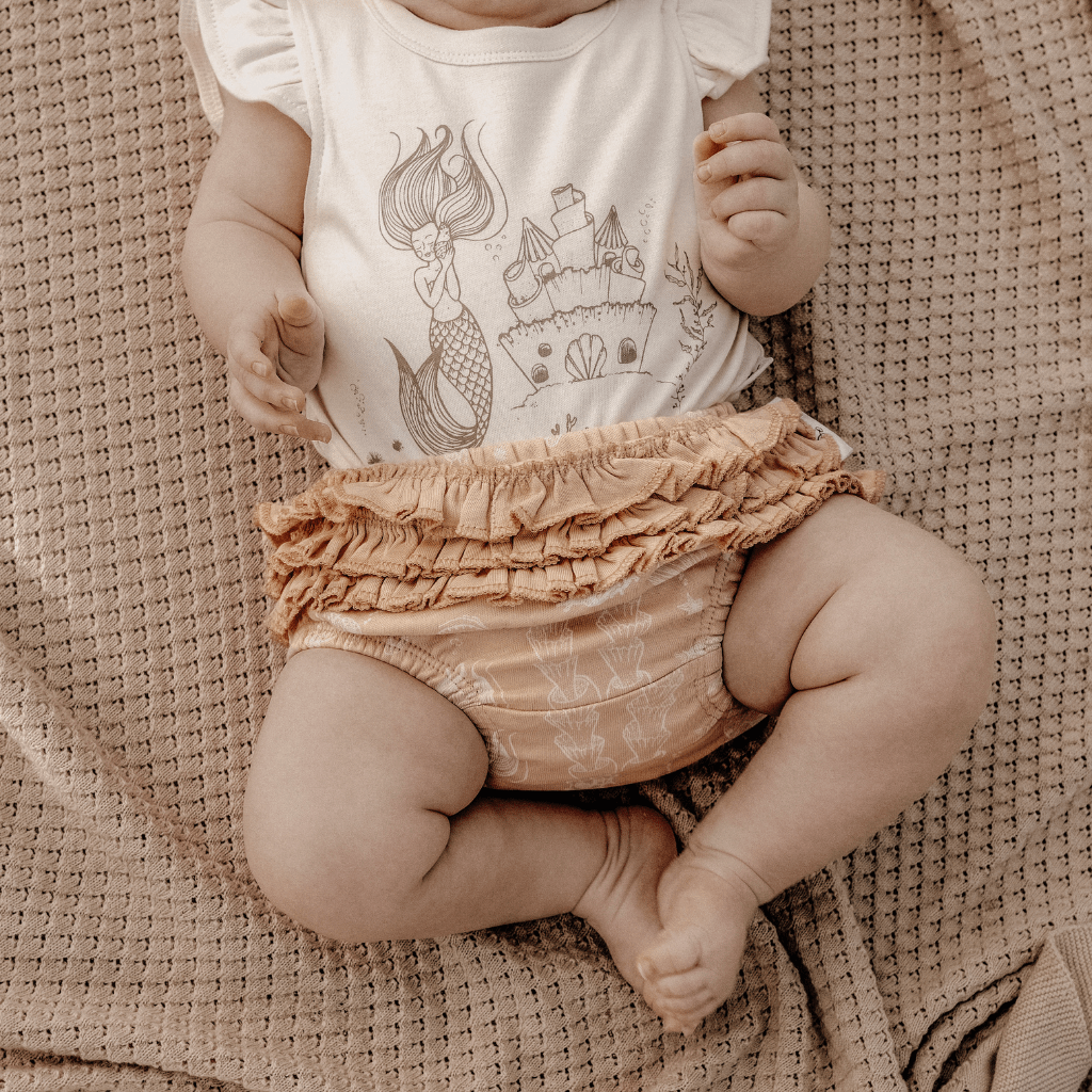 Close-up-of-Cute-Baby-Legs-Wearing-Aster-and-Oak-Organic-Mermaid-Ruffle-Bloomers-Naked-Baby-Eco-Boutique