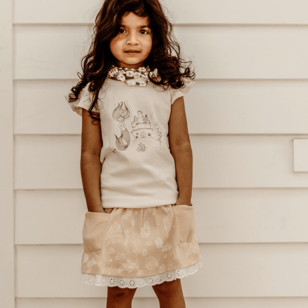 Little-Girl-with-Hands-in-Pockets-Wearing-Aster-and-Oak-Organic-Mermaid-Pocket-Skirt-Naked-Baby-Eco-Boutique