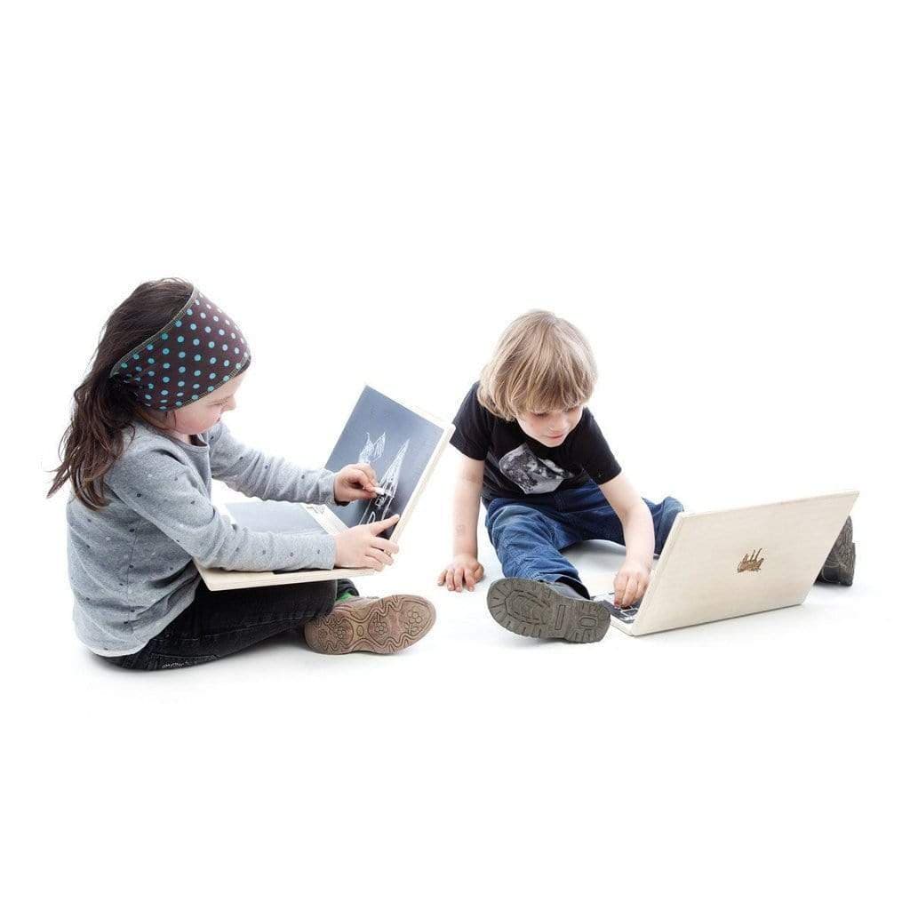 Two children sitting on the floor with laptops.