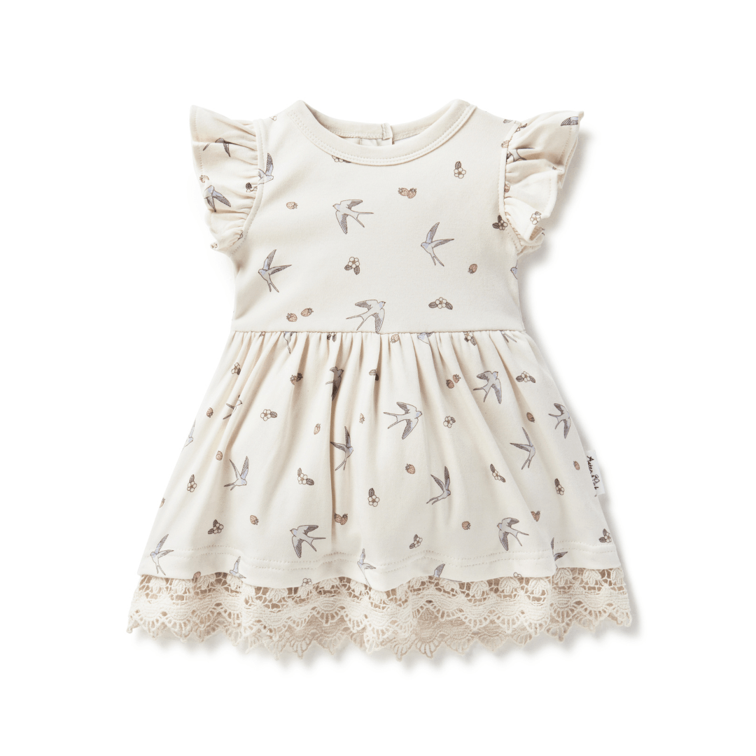 Off-white dress for babies and kids, featuring a hand-illustrated swallow and strawberry print, ruffle sleeves, and full skirt trimmed with delicate lace