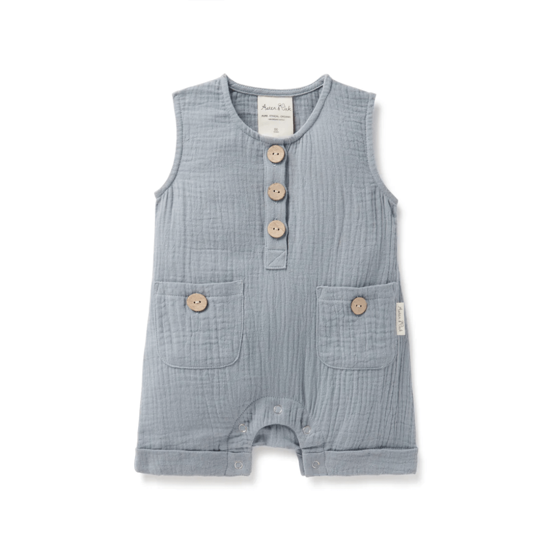 A baby boy's Aster & Oak Organic Slate Blue Muslin Romper with buttons, perfect for summer.