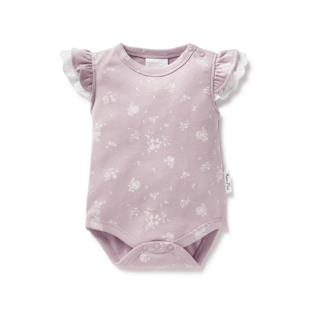 This Aster & Oak Organic Cotton Willow Floral Flutter Onesie features playful ruffles and delicate floral accents.