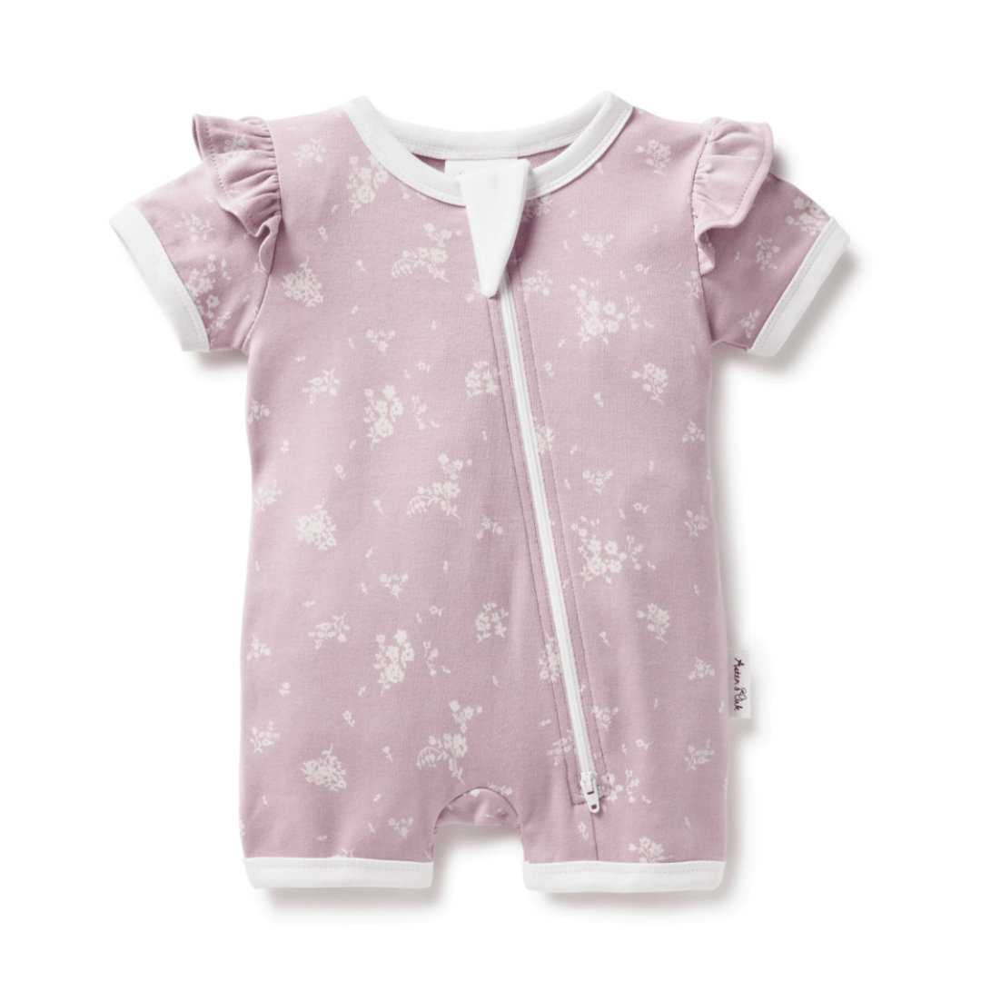An Aster & Oak Organic Cotton Flutter Sleeve Zip Romper with a pink floral print, specially designed for delicate skin.