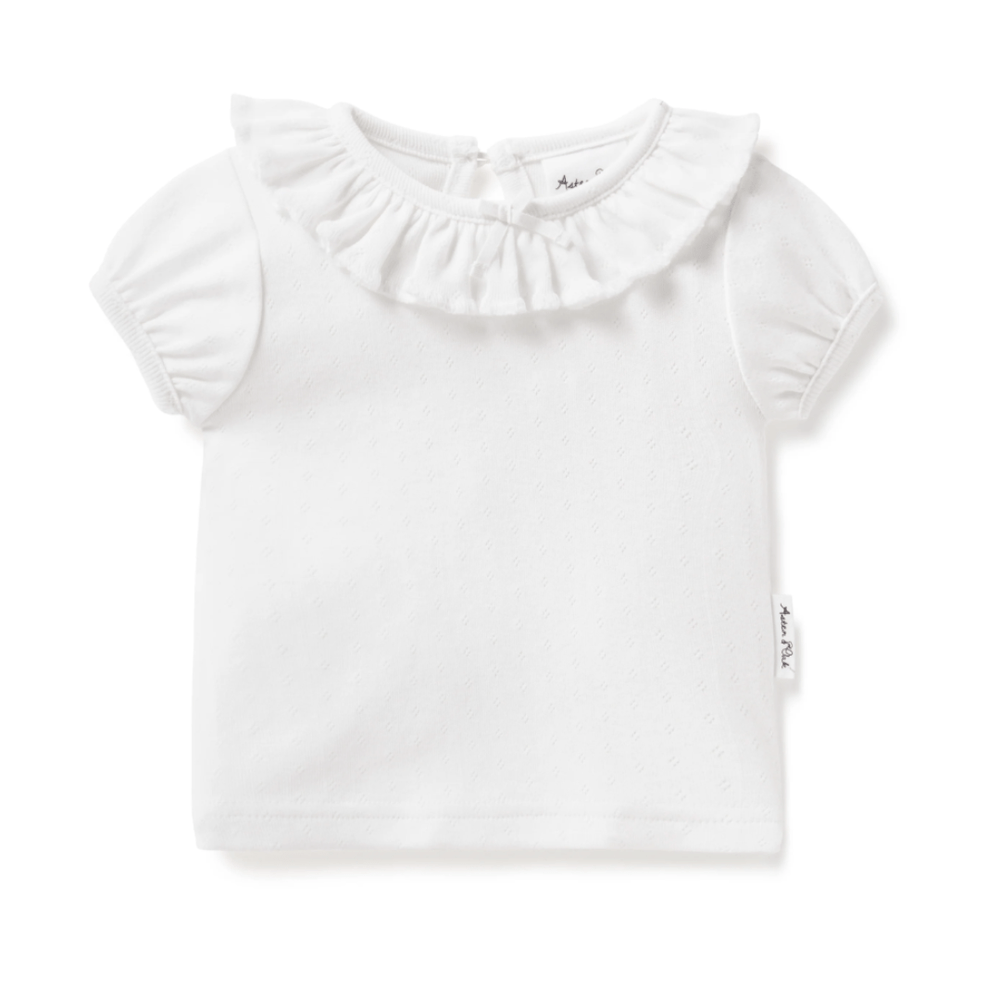 An Aster & Oak Organic Cotton Pointelle Ruffle Top made of organic cotton with a ruffled collar.