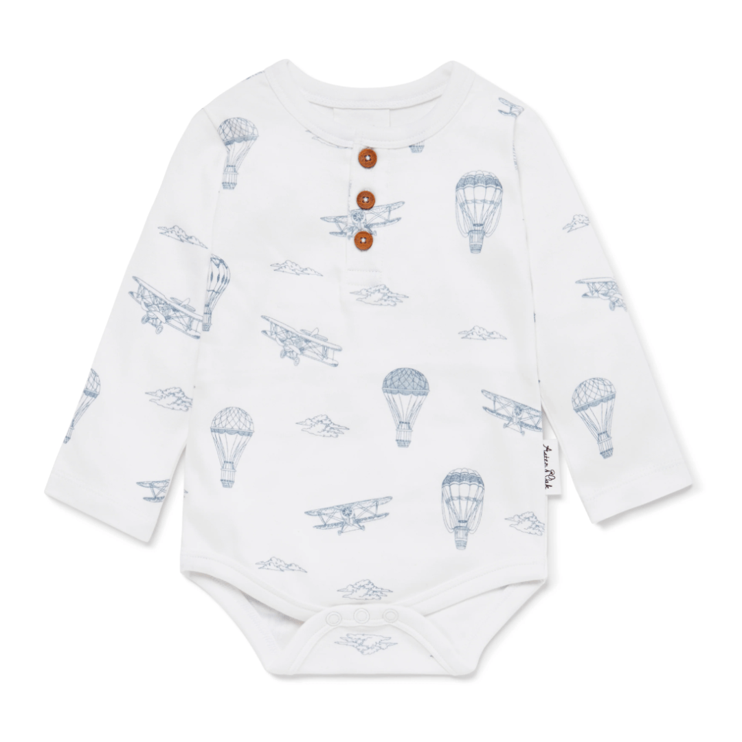 Aster & Oak Organic Henley Long-Sleeved Onesie with airplane and hot air balloon print and wooden button details.