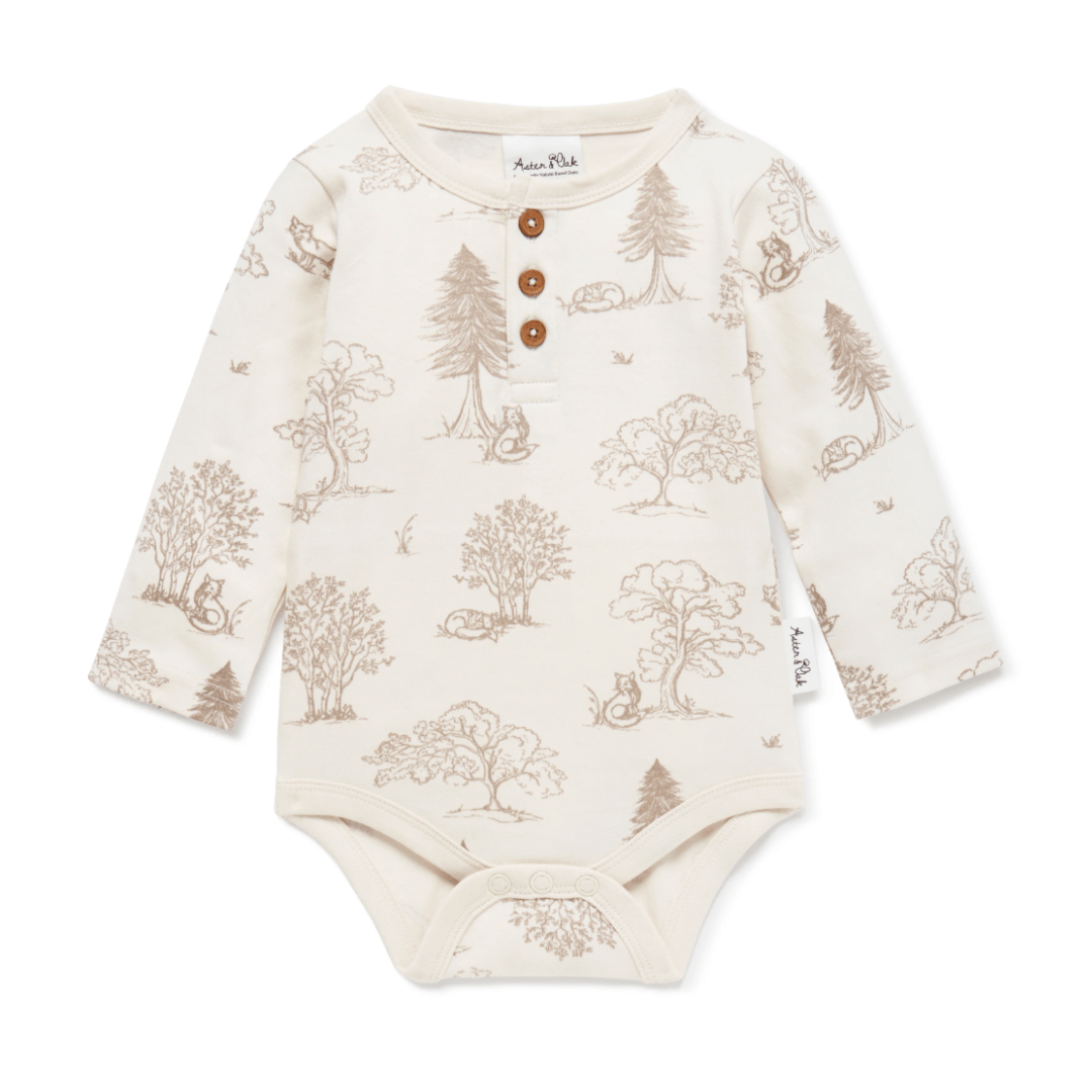 Aster & Oak Organic Henley Long-Sleeved Onesie with GOTS-certified organic cotton, featuring a hand-illustrated woodland print and snap buttons.