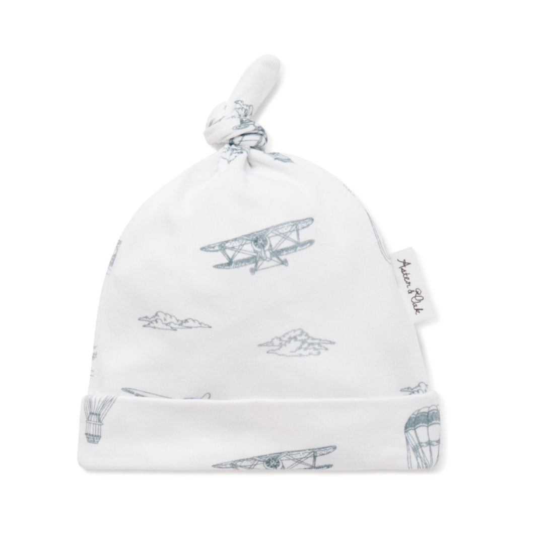 Aster & Oak Organic Knot Baby Hat with airplane pattern on isolated background.