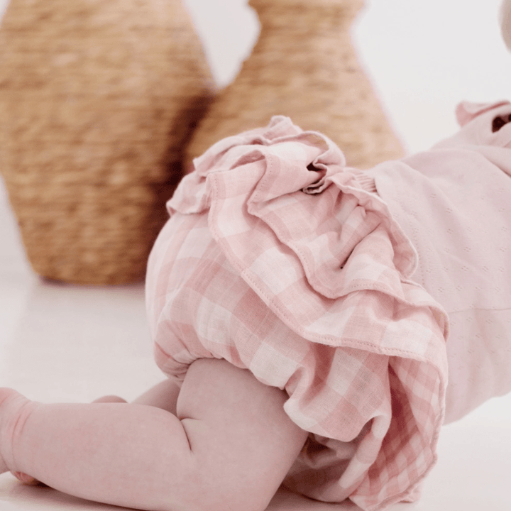 Close-Up of Baby Crawling In Front Of Rattan Vases, Wearing Pink & White Gingham Organic Baby Ruffle Bloomers
