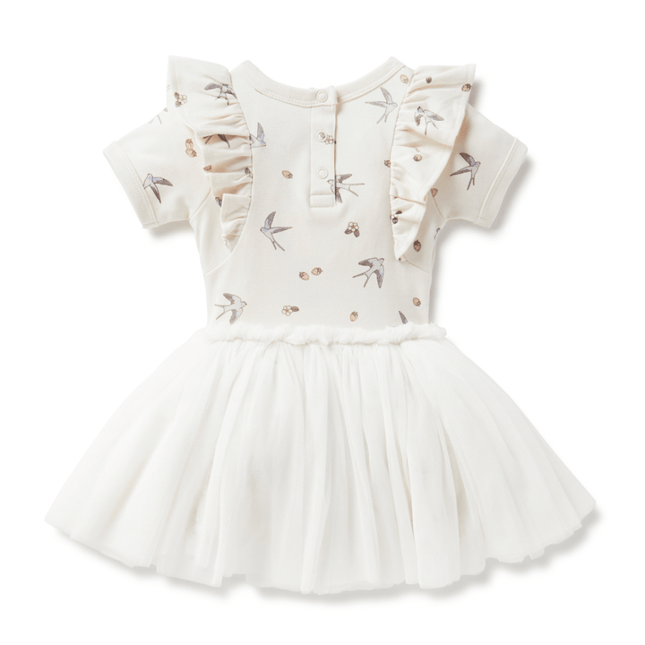 Back view of beautiful dress for babies and kids featuring a delicate hand-drawn swallow and strawberry print on the top half, short sleeves with a ruffle at the shoulder, three snaps at the neck, and a tulle skirt