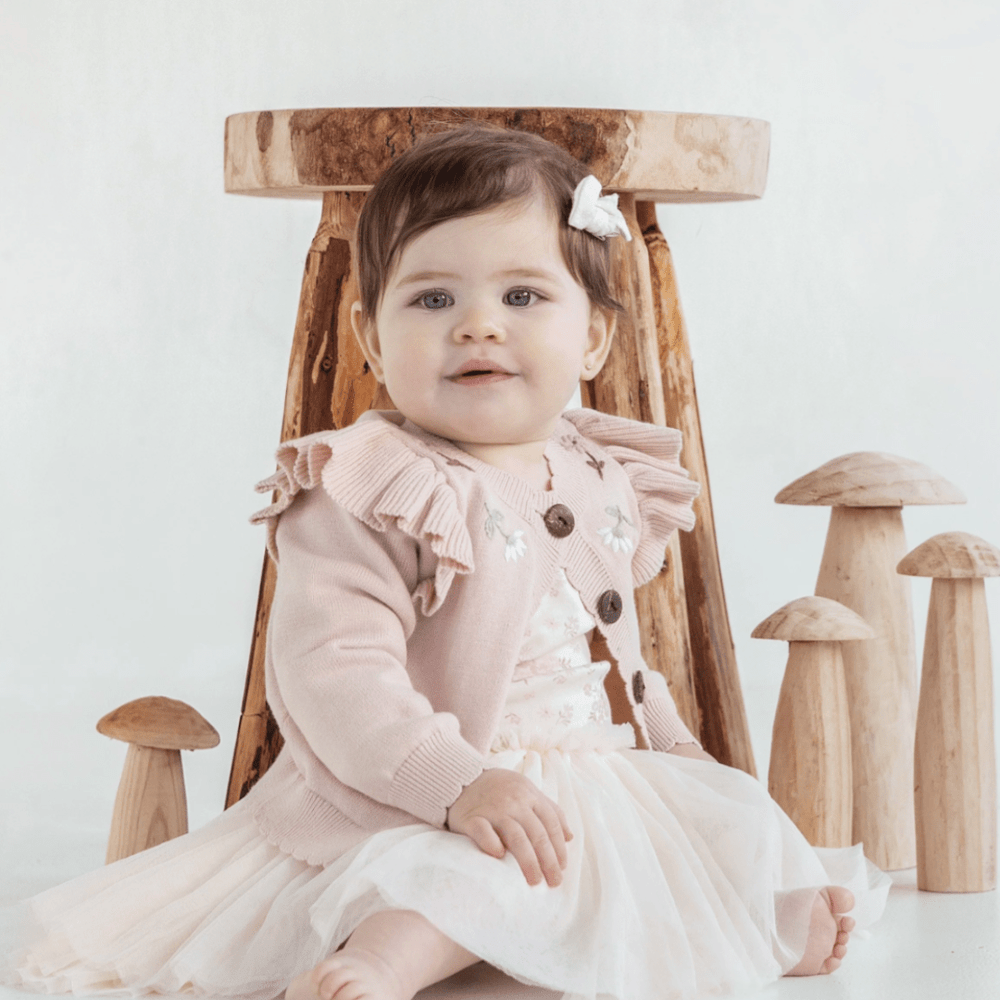 Beautiful-Baby-Girl-Sitting-Wearing-Aster-and-Oak-Organic-Ruffle-Knit-Cardigan-Naked-Baby-Eco-Boutique