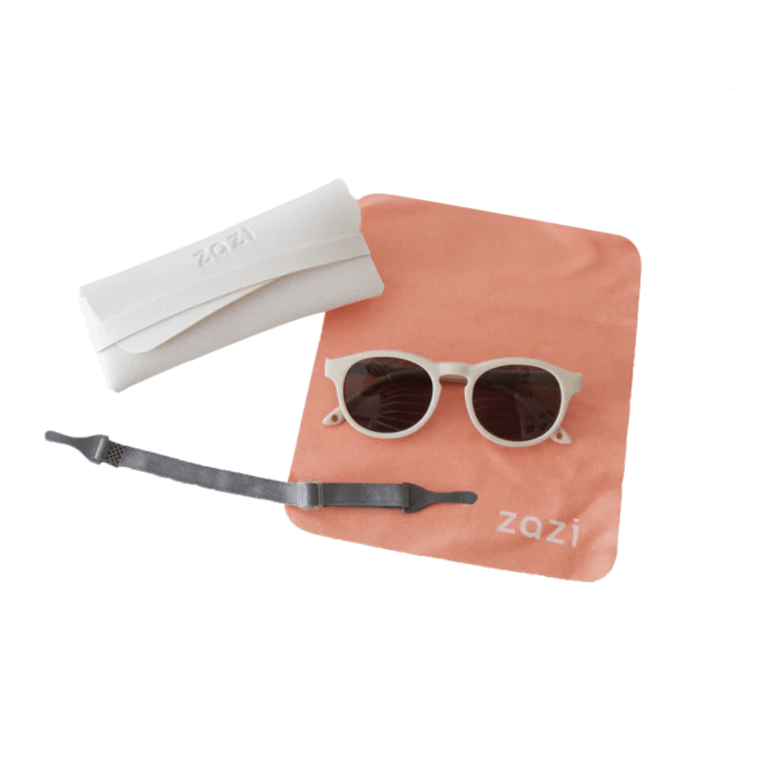 A pair of Zazi Shades Baby & Toddler Sunglasses with polarized clarity and UV400 protection resting on a table, accompanied by a pouch.