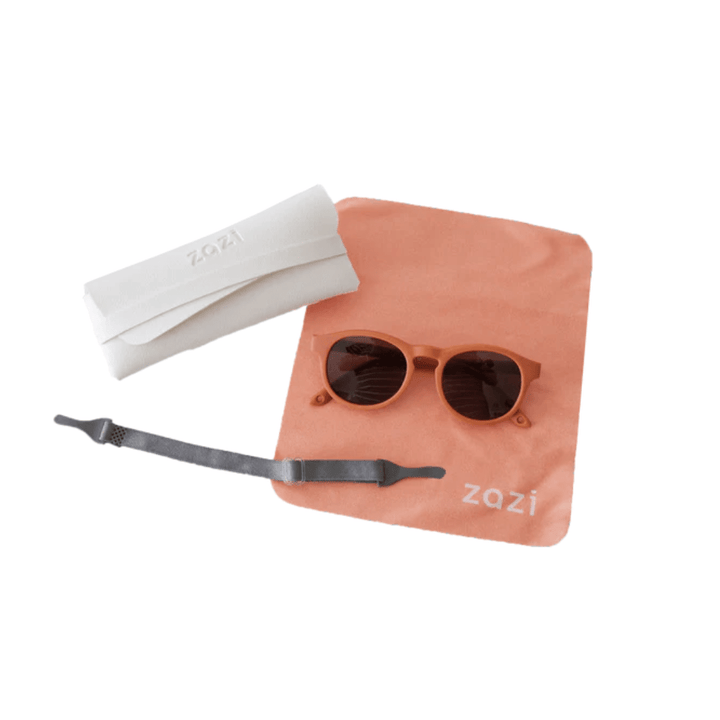 A pair of Zazi Shades Baby & Toddler Sunglasses with UV400 protection and polarized clarity, neatly placed on a table inside a pouch.