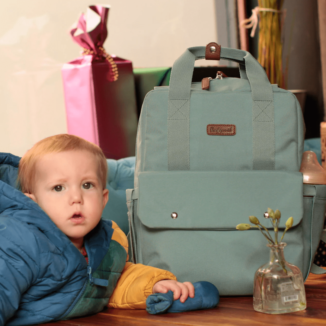 Child-Sitting-with-Babymel-Georgi-Eco-Convertible-Nappy-Backpack-Aqua-Naked-Baby-Eco-Boutique  1080 × 1080px