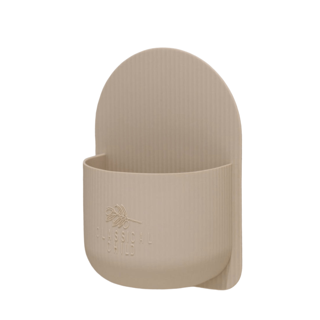 A beige Classical Child silicone plant holder with a handle, perfect as bathroom decor.