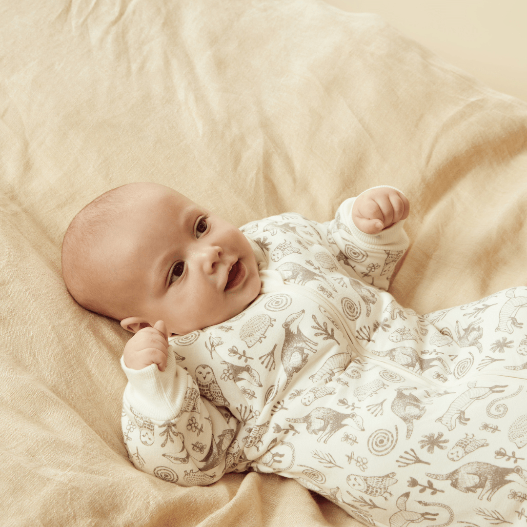Close-Up-Of-Happy-Baby-Wearing-Wilson-And-Frenchy-Organic-Long-Sleeved-Winter-Sleeping-Bag-Tribal-Woods-Naked-Baby-Eco-Boutique