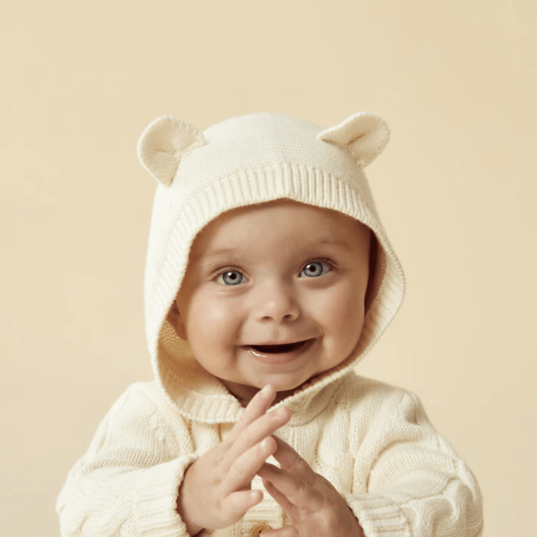Close-Up-Of-Happy-Baby-With-Hood-Up-Wearing-Wilson-And-Frenchy-Knitted-Cable-Jacket-Ecru-Naked-Baby-Eco-Boutique