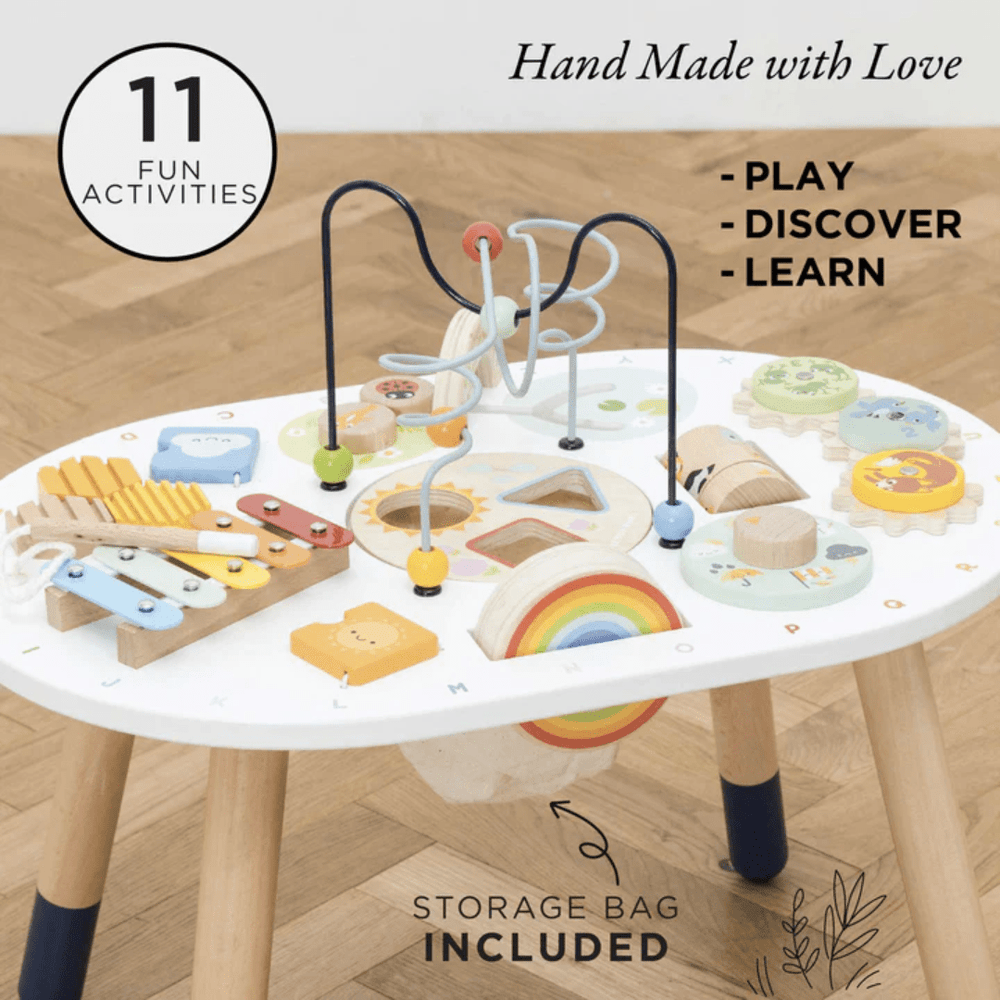 The Le Toy Van Activity Table, a Le Toy Van eco-friendly gift, is a sensory toy for toddlers that features a variety of toys on its wooden surface.