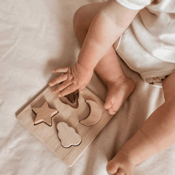 Close-Up-Of-Over-The-Dandelions-Wooden-Puzzle-With-Little-Baby-Feet-Naked-Baby-Eco-Boutique