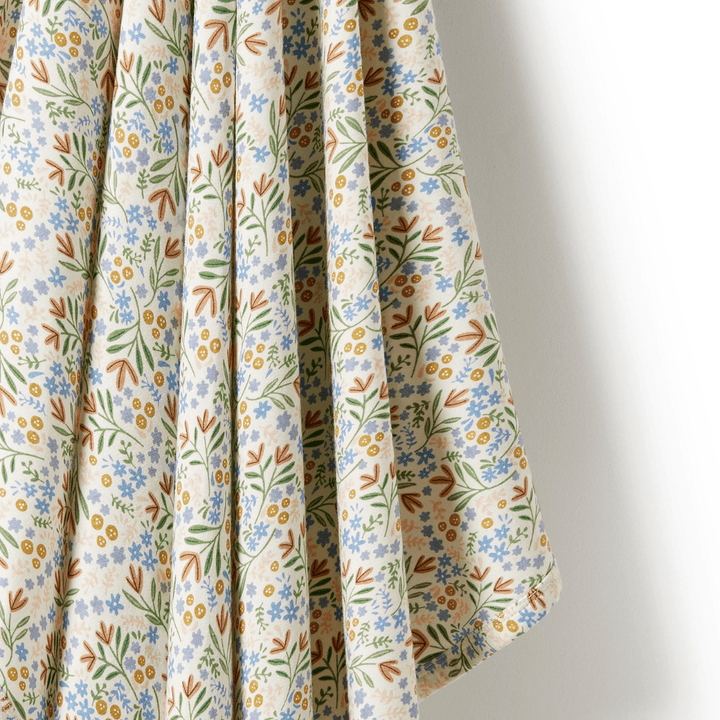 Wilson & Frenchy Organic floral patterned fabric hanging against a white background, perfect for a luxury Wilson & Frenchy Baby Swaddle Blanket.