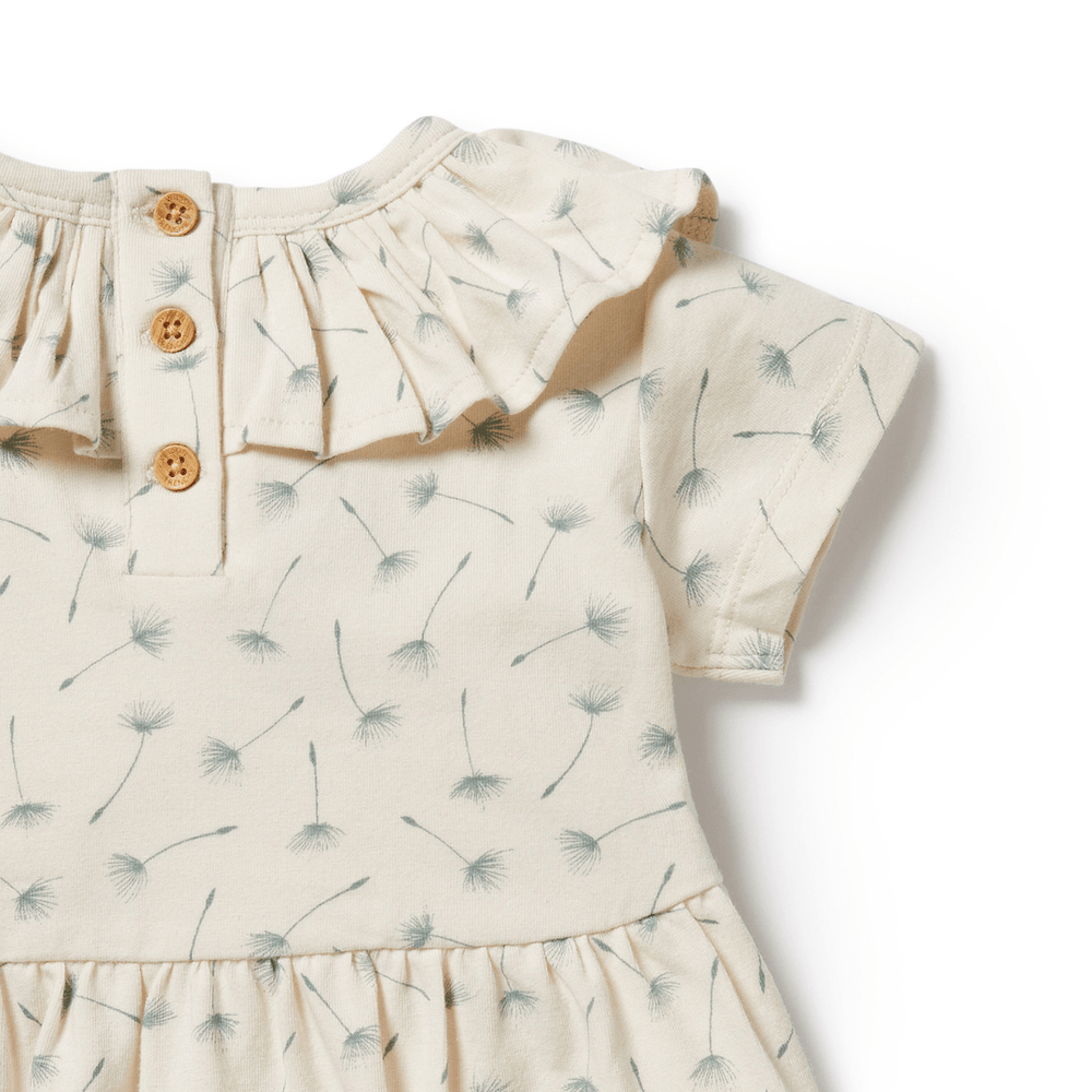A close up of a Wilson & Frenchy Float Away Organic Ruffle Dress - LUCKY LAST - 6-12 MONTHS ONLY, perfect for warm-weather bliss.