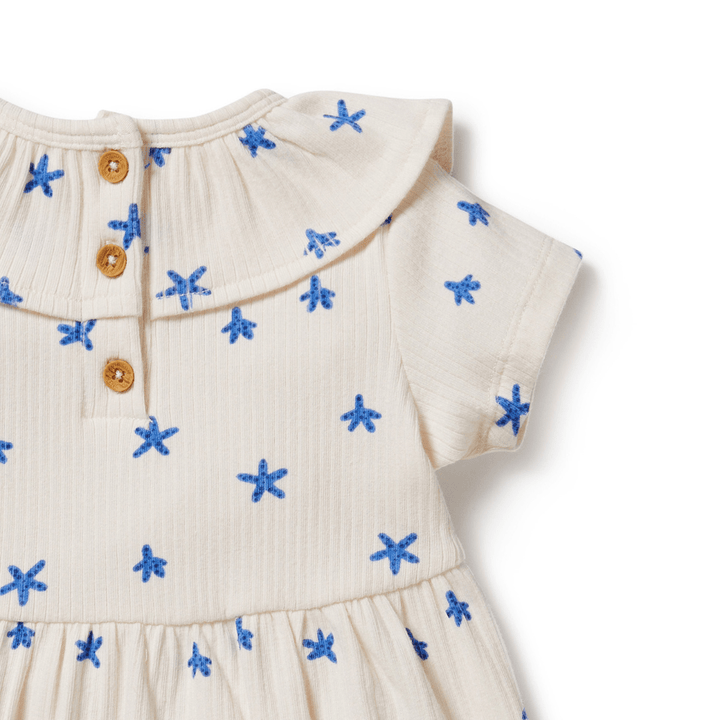 A Wilson & Frenchy Tiny Starfish Organic Rib Ruffle Dress - LUCKY LAST - 18-24 MONTHS ONLY adorned with tiny starfish and blue stars.