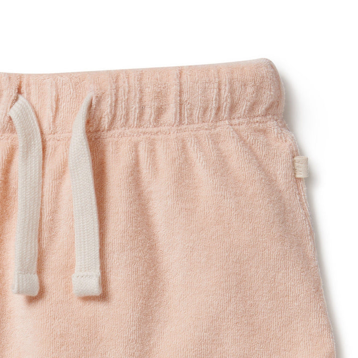 A comfortable Wilson & Frenchy Organic Terry Cuffed Shorts made from organic cotton, featuring a soft pink color and a white drawstring.