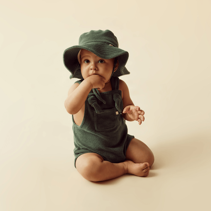 A baby in a Wilson & Frenchy Organic Terry Sunhat - LUCKY LAST - SUN DIAL - 6-12 MONTHS.