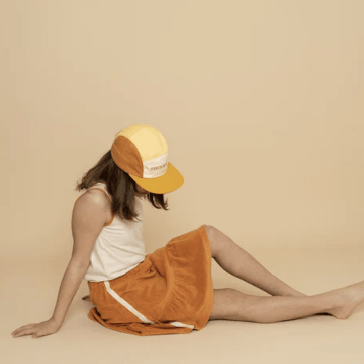 Girl-Wearing-Grech-And-Co-Organic-Anti-UV-5-Panel-Hat-Mellow-Yellow-Sienna-Naked-Baby-Eco-Boutique