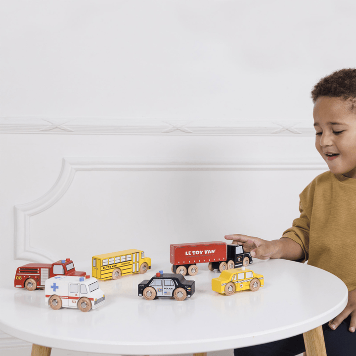 Happy-Boy-At-The-Table-Playing-With-Le-Toy-Van-New-York-Set-Of-Cars-Naked-Baby-Eco-Boutique