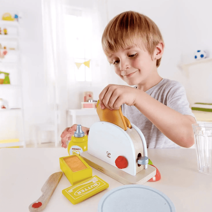 Happy-Boy-Making-Toast-With-Hape-Pop-Up-Toaster-Naked-Baby-Eco-Boutique