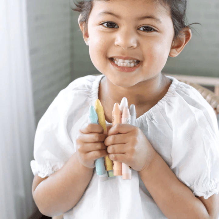 Happy-Girl-Holding-Honeysticks-Pastel-Jumbo-Beeswax-Crayons-Naked-Baby-Eco-Boutqiue