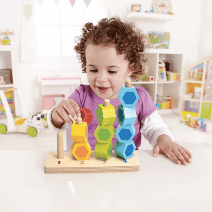 Happy-Girl-Playing-With-Hape-Counting-Stacker-Naked-Baby-Eco-Boutique