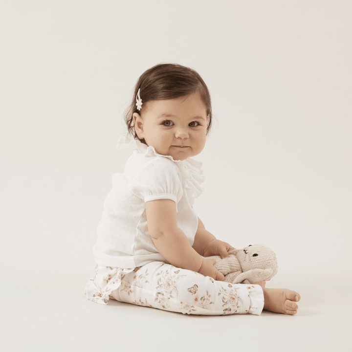 Happy-Girl-Sitting-Wearing-Aster-And-Oak-Organic-Cotton-Butterfly-Garden-Leggings-Naked-Baby-Eco-Boutique