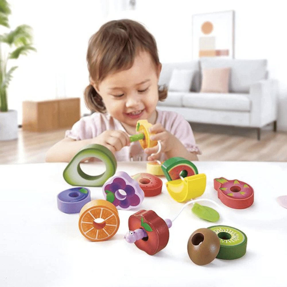 Happy-Little-Child-Treading-Fruit-With-Hape-Caterpiller-Fruit-Feast-Naked-Baby-Eco-Boutique