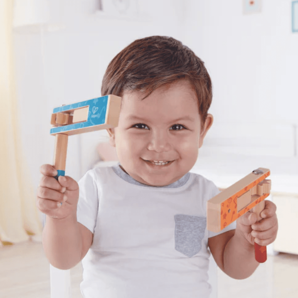 Happy-Smiling-Boy-Playing-With-Hape-Cheer-A-Long-Noisemaker-Naked-Baby-Eco-Boutique