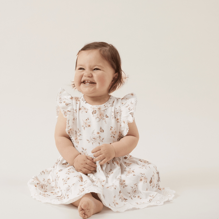 Happy-Smiling-Girl-Wearing-Aster-And-Oak-Organic-Butterfly-Ruffle-Dress-Naked-Baby-Eco-Boutique