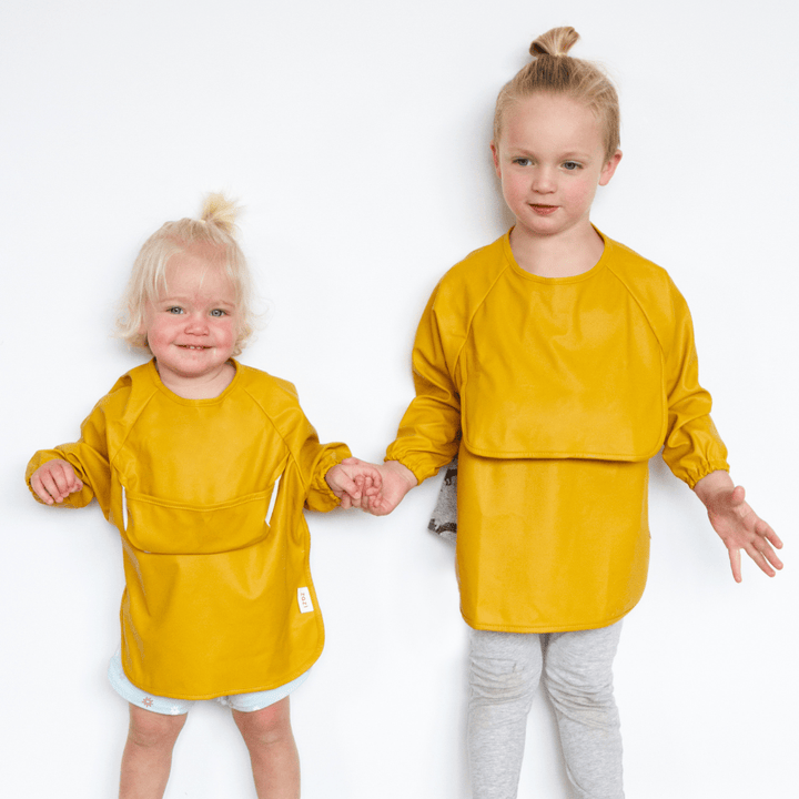 Two little girls wearing Zazi Recycled Full-Sleeved Bibs (Multiple Variants).