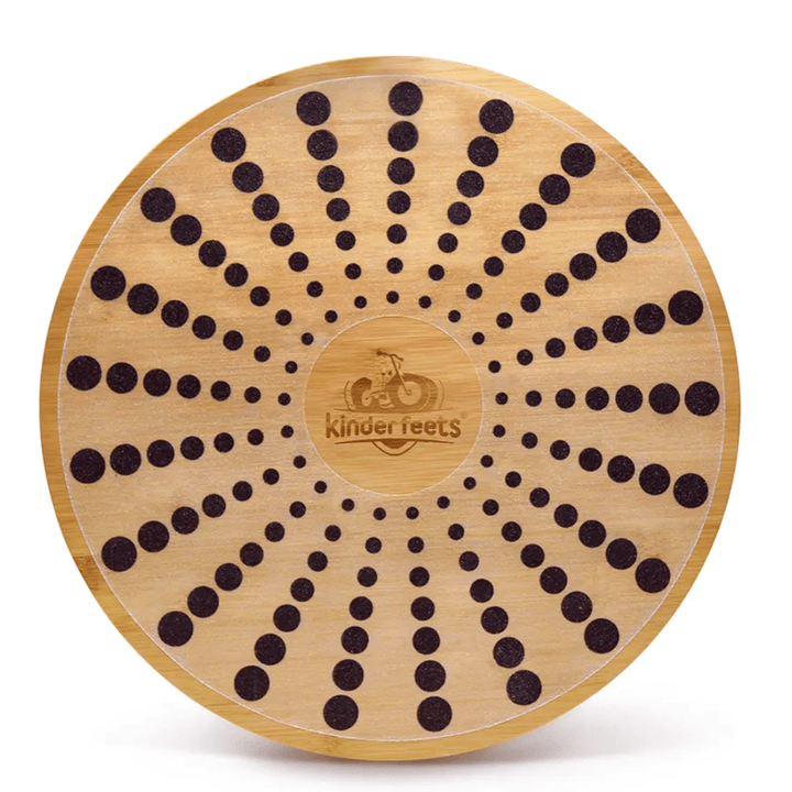 An eco-friendly Kinderfeets Bamboo Balance Disk with black dots on it.