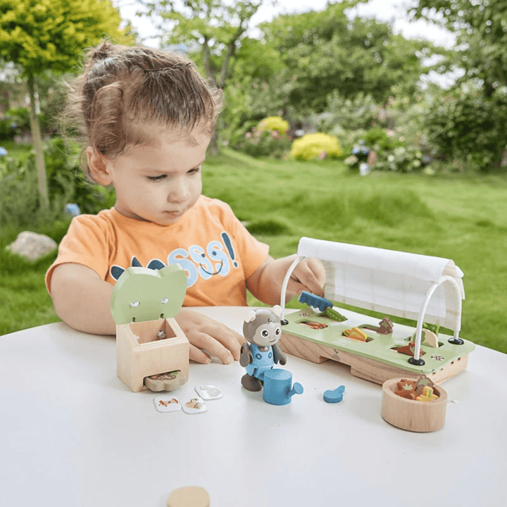 Litlle-One-Playing-With-Hape-Green--Planet-Greenhouse-Set-Naked-Baby-Eco-Boutique