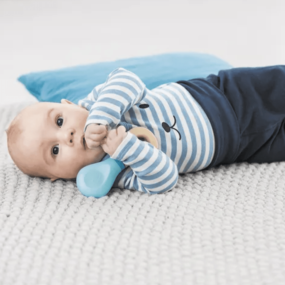Little-Baby-Holding-On-To-Hape-Rattle-Naked-Baby-Eco-Boutique