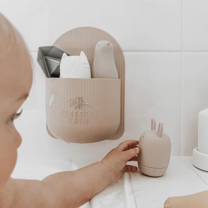 A baby is playing with a Classical Child Silicone Bath Toys Set in a bathroom.