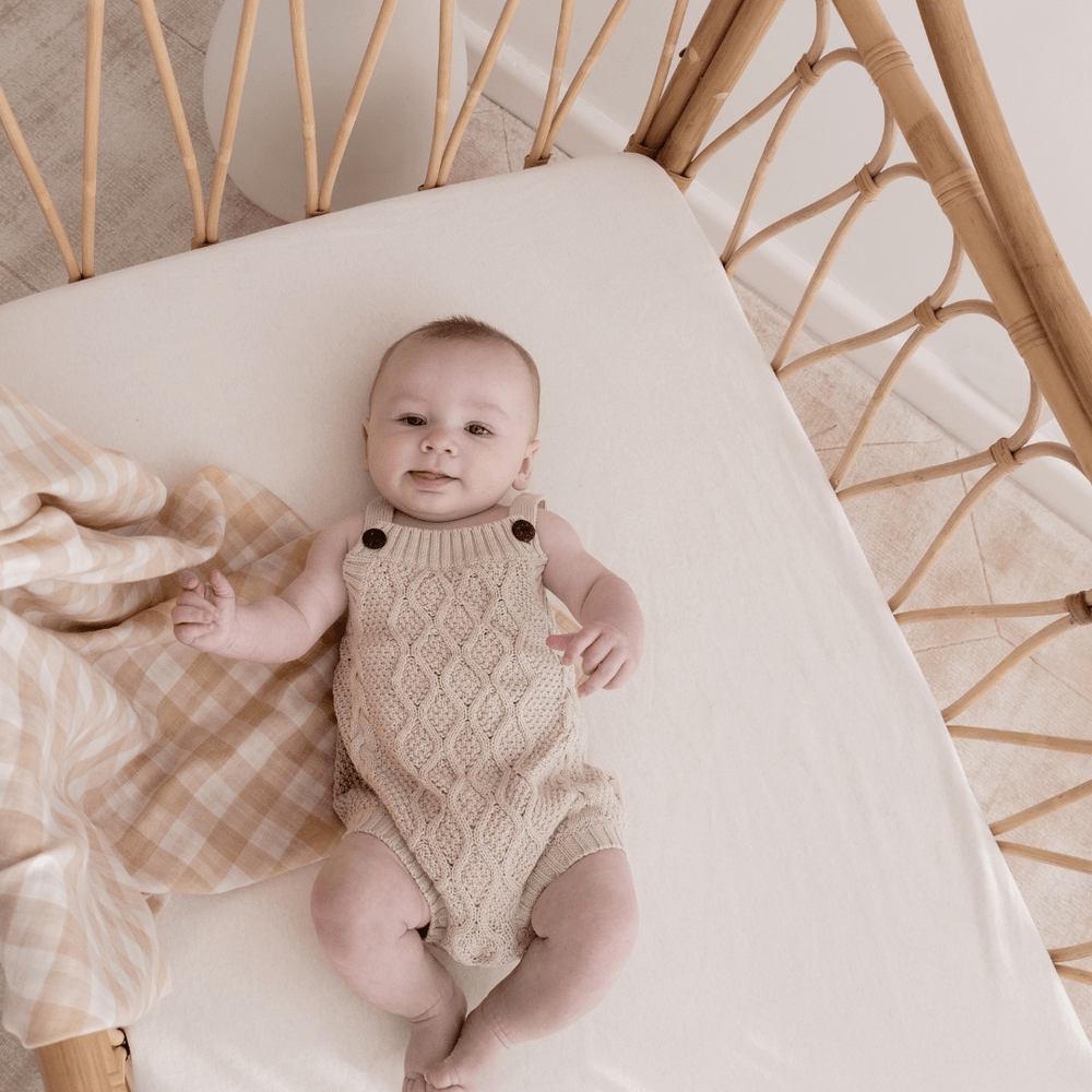 Little-Baby-In-Cot-Wearing-Aster-AAnd-Oak-Organic-Cotton-Cable-Knit-Romper-Naked-Baby-Eco-Boutique