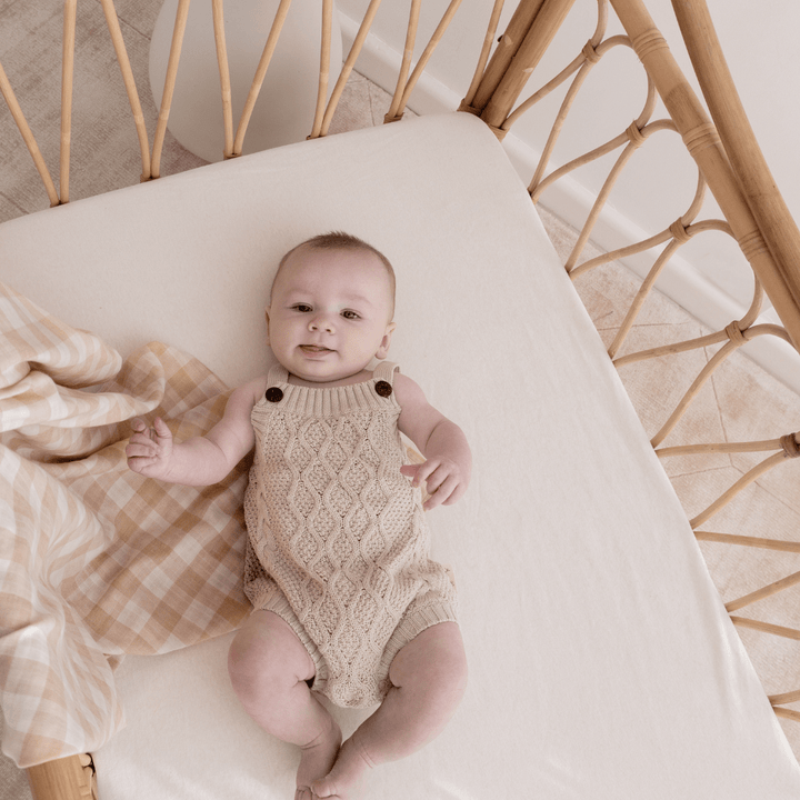 Little-Baby-In-Cot-Wearing-Aster-AAnd-Oak-Organic-Cotton-Cable-Knit-Romper-Naked-Baby-Eco-Boutique